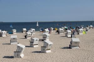 韦斯特兰Mein Urlaub auf Sylt的沙滩上,沙滩上摆放着椅子,人满为患