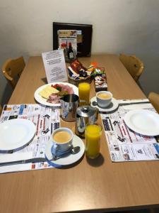 弗鲁蒂根辛普朗餐厅酒店的一张桌子,上面放有盘子,咖啡杯和报纸