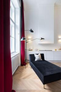 布达佩斯Erkel Boutique Apartment–Chic flat by Market Hall的客厅配有黑色沙发和红色窗帘