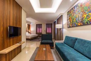 泗水Great Diponegoro Hotel Surabaya的带沙发和电视的客厅