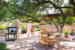 圣安东尼奥Hyatt Vacation Club at Wild Oak Ranch的一位女士在带桌椅的庭院中散步