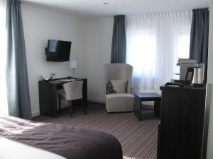 德科赫Boutique Hotel de Zwaluw的酒店客房设有一张床、一张书桌和一台电视机。