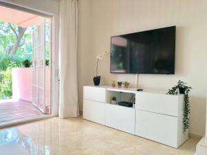 马贝拉Apartamento Guadalmina - Golf & Playa - Marbella的一间客厅,客厅内配有白色梳妆台上的电视