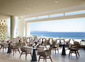 吉奥塔略Mayia Exclusive Resort & Spa - Adults Only的一间带桌椅的海景餐厅