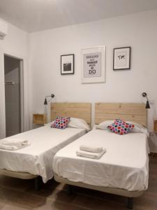 先波苏埃洛斯Apartamentos Ciempozuelos的卧室内两张并排的床