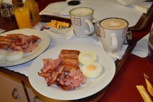 土乌巴阳光汽车旅馆的两盘早餐食品和两杯咖啡