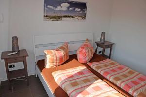 奥斯特巴德·哥伦Ferienhaus in Goehren的一间卧室配有两张带枕头的床。