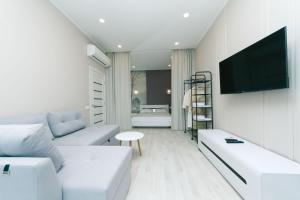 基辅Apartment in Smart Plaza的客厅配有白色家具和平面电视