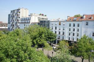 巴黎埃德加基内酒店的树木繁茂的城市中的一群建筑