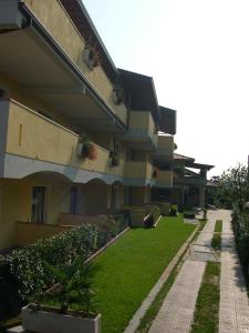 马内尔巴米拉拉戈住宅客房及公寓酒店的一座建筑旁边绿色庭院的建筑