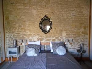 Saint-Georges-lès-BaillargeauxLe Haut Fontaine : minis maisons de charme的卧室配有一张壁挂镜子的床