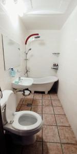 南原市南原酒店的浴室配有卫生间、浴缸和水槽。