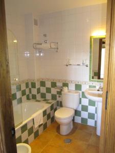 Barajas de GredosHotel Rural La Dehesilla的浴室配有卫生间、浴缸和水槽。