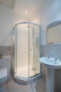 克利夫罗天鹅宾馆的一间带玻璃淋浴和水槽的浴室