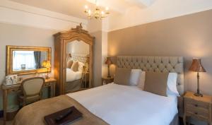 克利夫罗天鹅宾馆的卧室配有一张白色大床和镜子