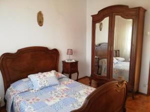 AtalaiaCasa Conceição的一间卧室配有一张床和一面大镜子