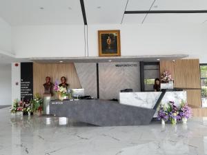 乌隆他尼9D Sport Hotel的一群人站在一个花朵满的大厅里