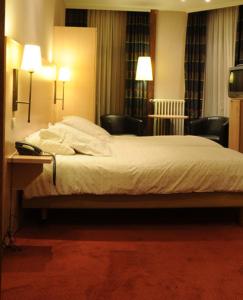 德哈恩埃斯卡佩德酒店的一间卧室配有一张带两把椅子和两盏灯的床。