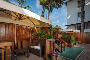 格连吉克Marsel Hotel的庭院设有木栅栏和遮阳伞。