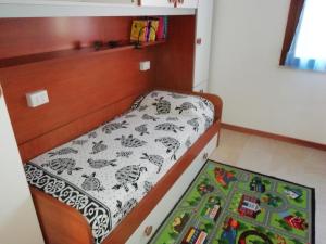 普佐伊杜撒丁岛海洋公寓的一间小卧室,配有床和地毯