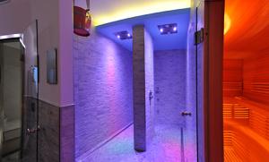 莱维科特尔梅Villa Flora的浴室的墙壁上配有紫色灯和淋浴。