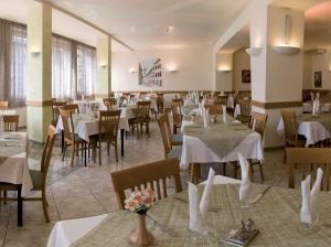 莱维科特尔梅Villa Flora的餐厅配有桌椅和白色的桌布
