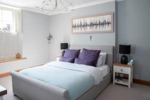 韦尔斯Boutique house central Wells的一间卧室配有一张带紫色枕头的大床
