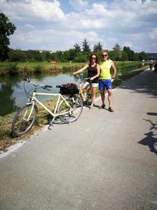 爱斯科利夫-圣卡米Villa Rose的两个人站在一辆自行车旁,在路上