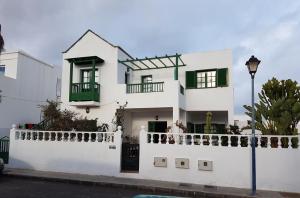 阿列塔Chelada 2的白色的房子,设有绿色的窗户和白色的围栏
