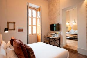 大加那利岛拉斯帕尔马斯VEINTIUNO Emblematic Hotels - Adults Only的酒店客房,配有床和电视