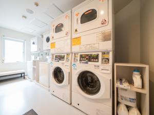 横滨新横滨超级酒店的洗衣房配有3台洗衣机和烘干机