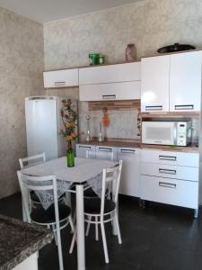 布罗塔斯Cantinho Aconchegante的厨房配有桌椅和冰箱。