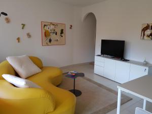 洛索内GRETA 29的客厅配有黄色沙发和电视