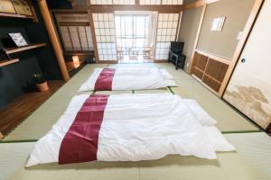 大阪Teradaya Osaka Ryokan 150m2 寺田屋大阪旅館 your own property sweet home in Osaka的房间里的一排床