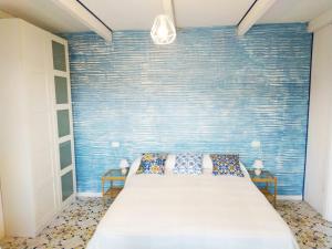 普罗基奥La Villa的一间卧室配有一张蓝色墙壁的床