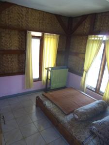 希维德Pondok Stevia Ciwidey的一间设有床铺的卧室,位于带窗户的房间内
