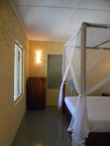 KalametiyaTaragala Chalets的一间卧室配有一张天蓬床和窗户