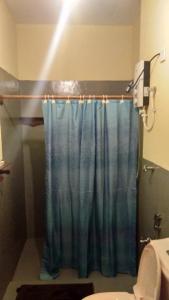 KalametiyaTaragala Chalets的一间带蓝色淋浴帘的淋浴的浴室