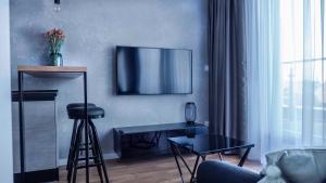 莱格尼察Apartament Wrocławska 29的客厅配有桌子和墙上的电视