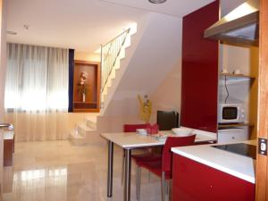 Corró de Vall维尔提酒店的厨房以及带桌子和红色椅子的用餐室。