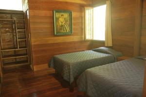 塔拉波托La Musa Verde的一间卧室设有两张床,墙上挂着一幅画