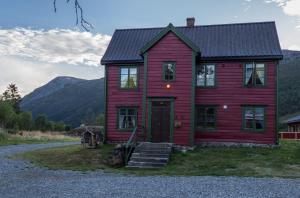 BorgundMaristuen Fjellferie的一座红色的房子,后面有山