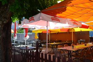 HornHotel Schiff的户外餐厅设有桌子和遮阳伞