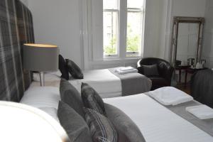 爱丁堡国际宾馆的酒店客房,配有两张床和椅子