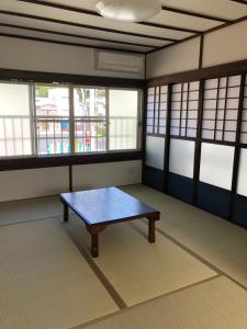 奄美Amami Weekly House Nico nico的一间窗户客房中间带桌子的房间