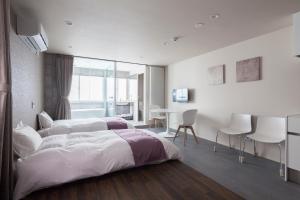 札幌Private house Kuranoya Sapporo的卧室配有一张床和一张桌子及椅子