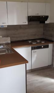 巴德茨维什安Marina View的厨房配有白色橱柜和炉灶烤箱。