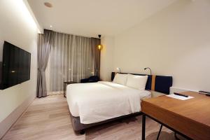 台中市探索私旅 的酒店客房配有一张床、一张书桌和一张书桌。