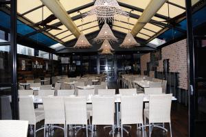 New LambtonDuke of Wellington Hotel的用餐室配有白色桌椅和吊灯。