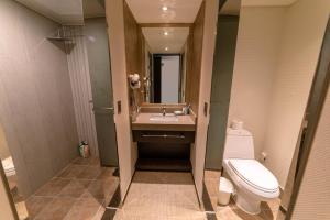 西归浦市济州宋山酒店的一间带卫生间、水槽和镜子的浴室